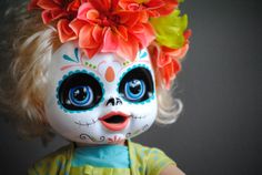 a doll with flowers in her hair wearing a colorful skull makeup make - up for day of the dead