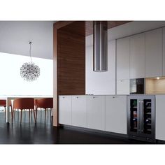 a modern kitchen with white cabinets and black flooring is seen in this image from the side