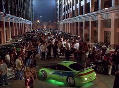 a group of people standing around a green sports car