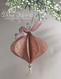 a pink ornament hanging from a tree with baby's breath flowers in the background