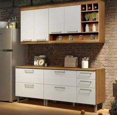 a refrigerator freezer sitting inside of a kitchen next to a brick wall