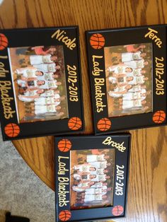 three framed pictures on top of a wooden table with basketballs in the bottom row