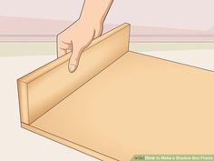 a person is opening a box with their thumb on the bottom drawer and pointing at it