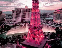 the eiffel tower is lit up in pink