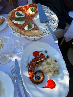 a table topped with plates filled with different types of food next to glasses and silverware