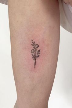 a small flower tattoo on the right side of the leg, which is black and white