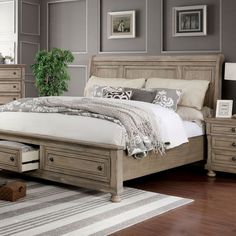 a large bed sitting in a bedroom next to a wooden dresser and chest of drawers