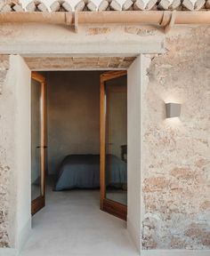 an open door leading to a bedroom with a bed in the corner and two lamps on either side