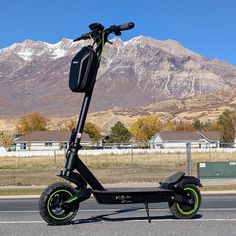 an electric scooter is parked on the side of the road with mountains in the background