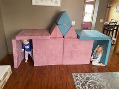 two children playing in a pink play house