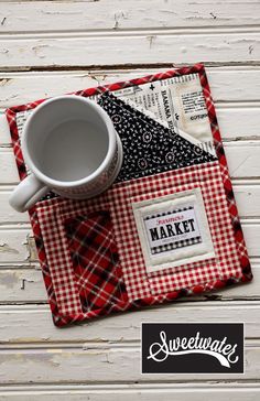 a cup and saucer sitting on top of a red checkered place mat with the words market