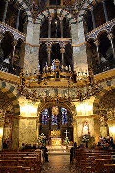 the inside of a church with pews and chandeliers