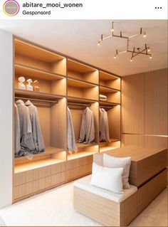 a large walk - in closet with wooden shelves and white pillows on the floor next to it