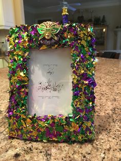 an ornate frame is adorned with colorful beads and sequins on the countertop