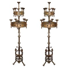 two metal candelabra stands with candles on them