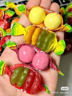 a person is holding three candy candies in their palm, and there are several different ones