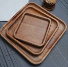 three square wooden trays sitting on top of a table