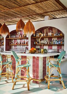 an outdoor bar with wicker chairs and hanging lights