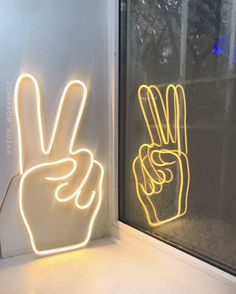 a neon sign that says peace is displayed next to a window with the word peace written on it