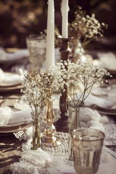 the table is set with white flowers and candles