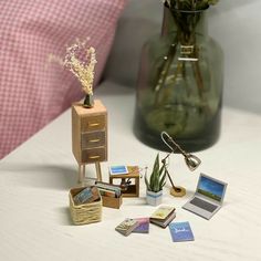 a table topped with a vase filled with flowers next to a pile of books and cards