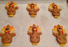 six decorated turkey cookies sitting on top of a pan