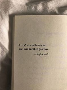 an open book sitting on top of a bed next to a white sheet with the words, i can't say hello to you and ask another goodbye