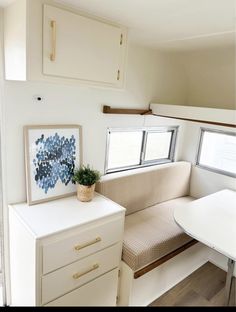 the interior of a camper with a couch, table and cabinets in it's corner