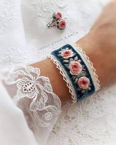 a woman's arm with two bracelets on it and pink flowers in the middle