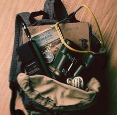 the contents of a backpack sitting on top of a wooden floor