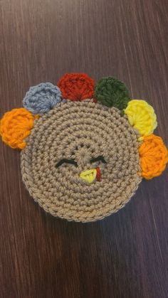 a crocheted turkey with multi colored pom poms on it's head