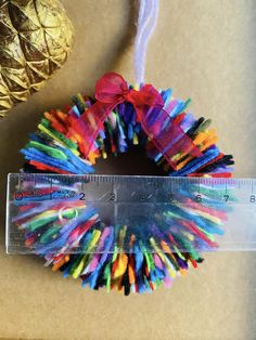 there is a ruler next to a multicolored wreath