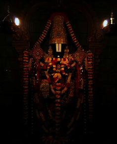 an intricately decorated statue is lit up in the dark