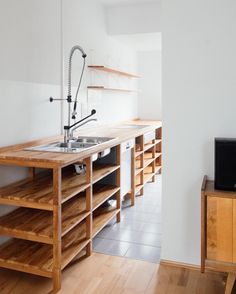 a kitchen with wooden shelves and a sink