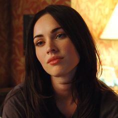 a close up of a person with long hair and a lamp in the background,