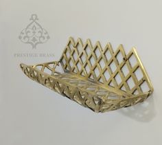 a gold metal basket on a white background with the words prestige brasss written below it