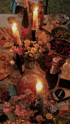 a table is set with candles, plates and other food items for a dinner party