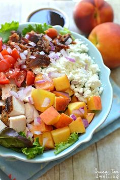 a salad with chicken, tomatoes, lettuce and other vegetables on a blue plate