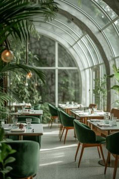 an indoor restaurant with green chairs and tables