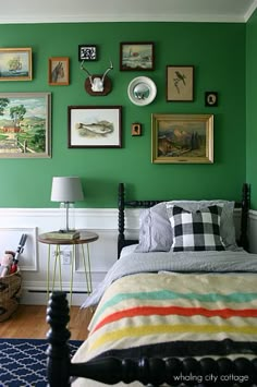 a bedroom with green walls and pictures on the wall