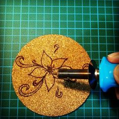 a person using a drill to make a flower on a piece of gold glittered paper