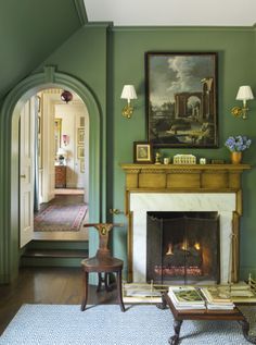 a living room filled with furniture and a fire place in front of a painting on the wall