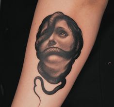 a woman's face with a snake wrapped around her arm and the image of a man on it