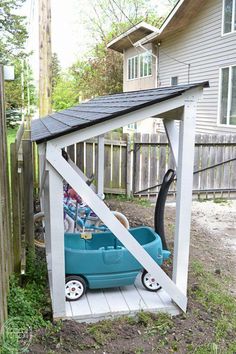 a blue toy car under a white wooden structure