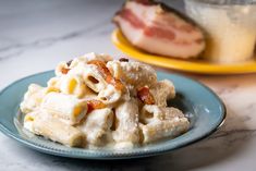 pasta with bacon and cheese on a blue plate