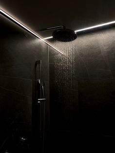 a shower head with the light on and rain coming down from it's side