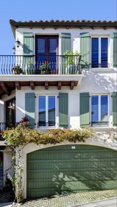 an apartment building with green shutters and balconies