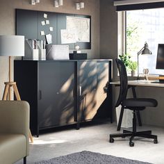 an office with a desk, chair and computer monitor on the table in front of a large window