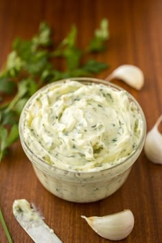 an image of a bowl of dip with garlic and parsley on the side for garnish