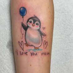 a penguin holding a balloon with the words i love you mom written on its arm